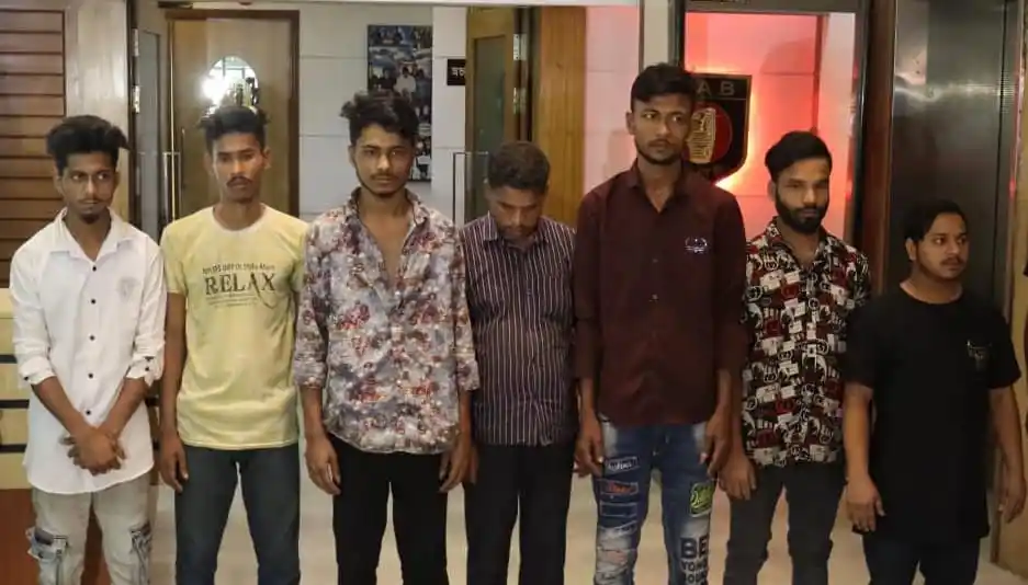 ছয় যুবক একসঙ্গে দাঁড়িয়ে, পেছনে চ্যানেল আই লোগো দেখা যাচ্ছে. Channel i News - চ্যানেল আই নিউজ
