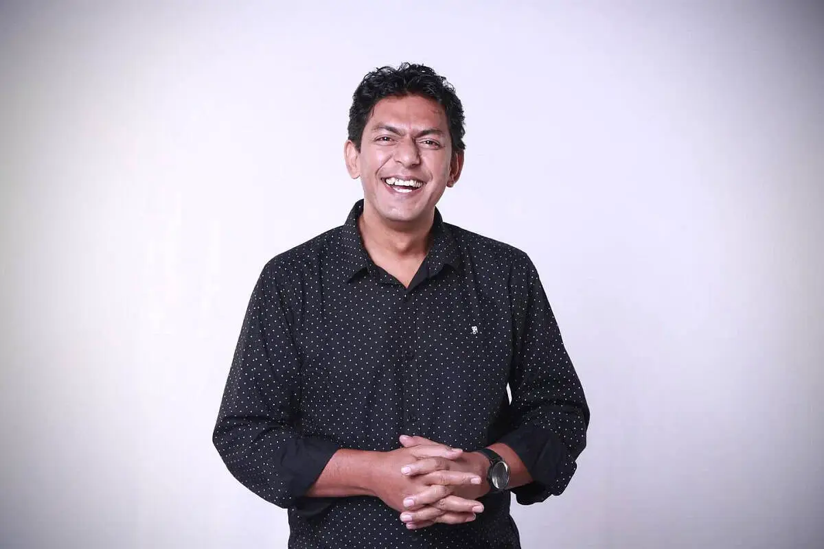 চঞ্চল চৌধুরী হাসিমুখে দাঁড়িয়ে, কালো পোশাক পরা. Channel i News - চ্যানেল আই নিউজ