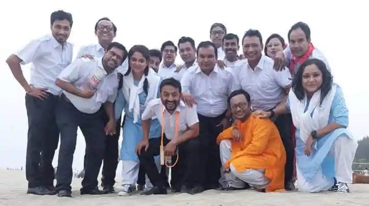 Group of young people and a monk posing on the beach in Bangladesh. Channel i News - চ্যানেল আই নিউজ