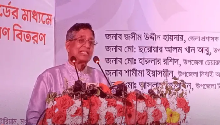 কৃষিমন্ত্রী বক্তব্য দিচ্ছেন, পেছনে বাংলায় লেখা পোস্টার. Channel i News - চ্যানেল আই নিউজ