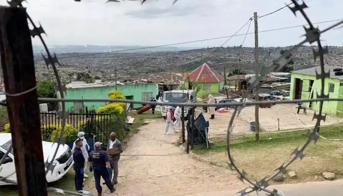 South African neighborhood scene with police and residents after a shooting incident. Channel i News - চ্যানেল আই নিউজ