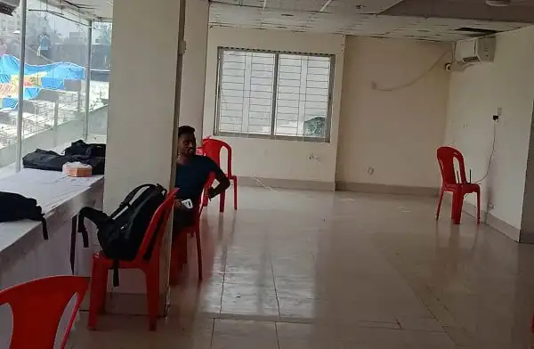 Empty press box with a man sitting on a red chair inside a Bangladesh sports venue. Channel i News - চ্যানেল আই নিউজ