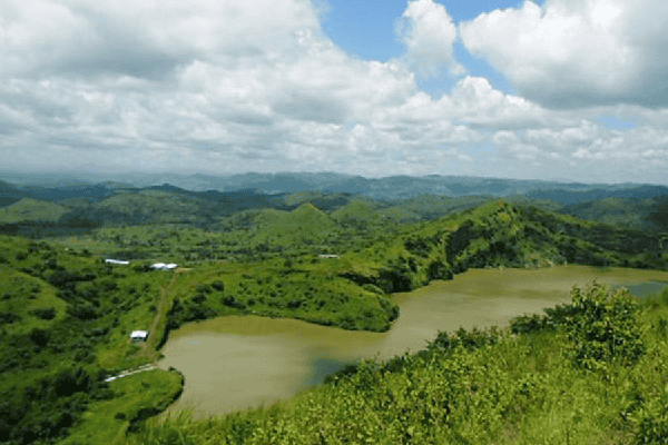Lush green hills and a river under a cloudy sky in Bangladesh. Channel i News - চ্যানেল আই নিউজ