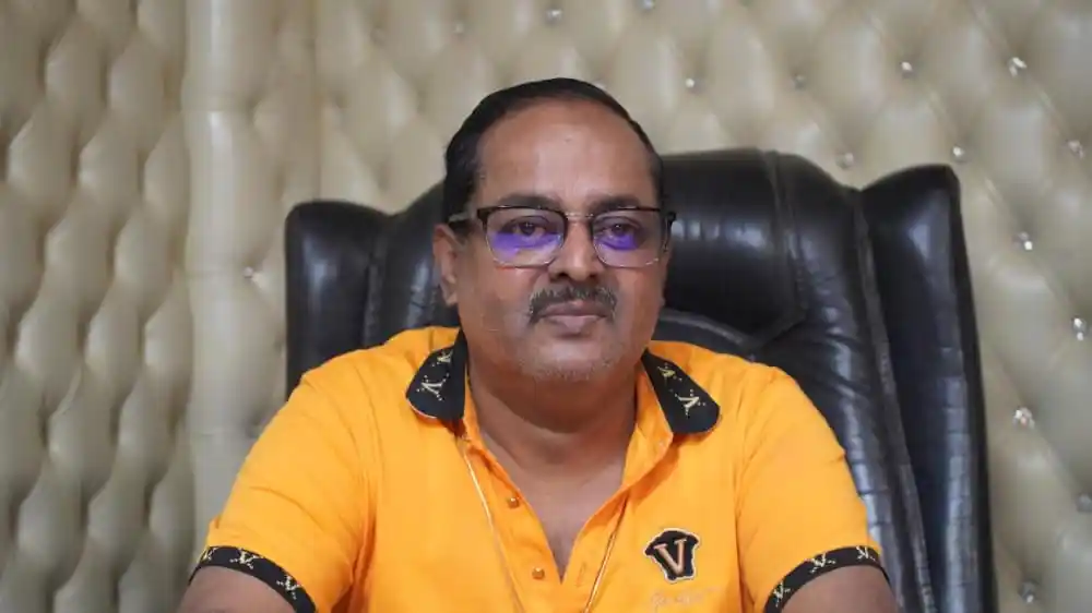 বাংলাদেশের একজন সংবাদ প্রতিবেদক, কালো চশমা ও হলুদ পোশাক পরা. Channel i News - চ্যানেল আই নিউজ