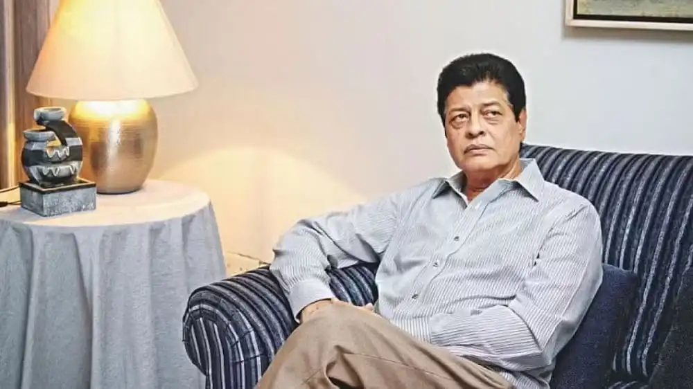 ফারুকের ছবি, তিনি বসে আছেন সোফায়, পেছনে ল্যাম্প ও টেবিল. Channel i News - চ্যানেল আই নিউজ