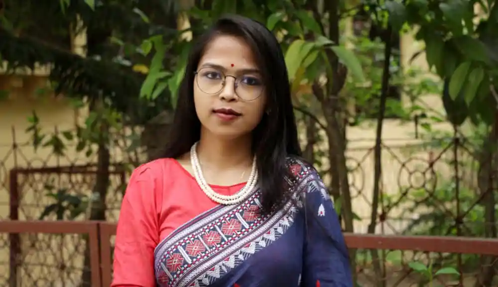বাংলাদেশি নারী সাংবাদিকের ছবি, গাছের পেছনে দাঁড়িয়ে. Channel i News - চ্যানেল আই নিউজ