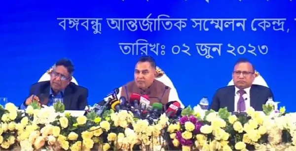 অর্থমন্ত্রী সংবাদ সম্মেলনে বক্তব্য দিচ্ছেন, পাশে দুই কর্মকর্তা।. Channel i News - চ্যানেল আই নিউজ