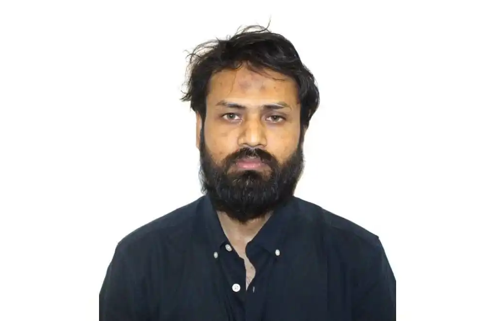 Portrait of a man with a beard wearing a dark shirt against a white background. Channel i News - চ্যানেল আই নিউজ
