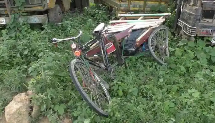 বেহাল অবস্থায় পড়ে থাকা একটি পুরানো সাইকেল, চারপাশে ঘাস ও গাছের ঝোপঝাড়. Channel i News - চ্যানেল আই নিউজ
