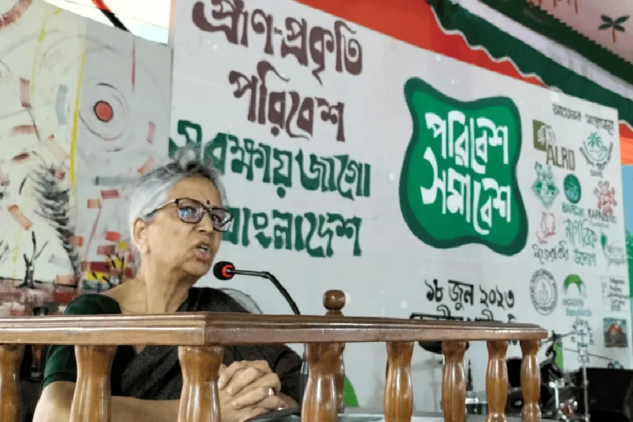 প্রেস কনফারেন্সে একজন নারী বক্তা, পেছনে বাংলা ভাষায় লেখা ব্যানার. Channel i News - চ্যানেল আই নিউজ