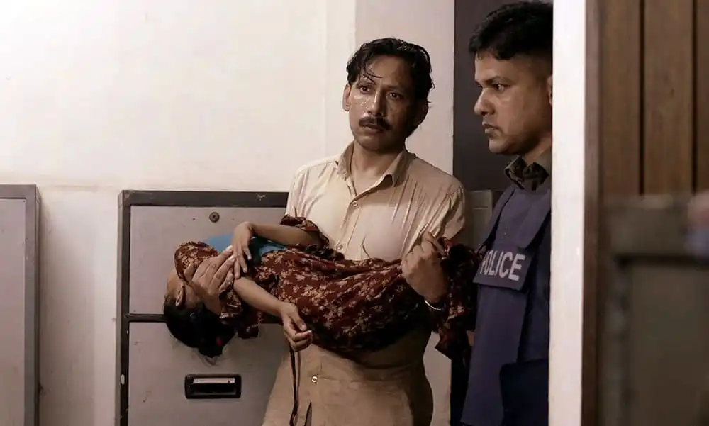 দুজন পুলিশ কর্মকর্তা একজন আহত ব্যক্তিকে হাসপাতালে নিয়ে যাচ্ছেন।. Channel i News - চ্যানেল আই নিউজ