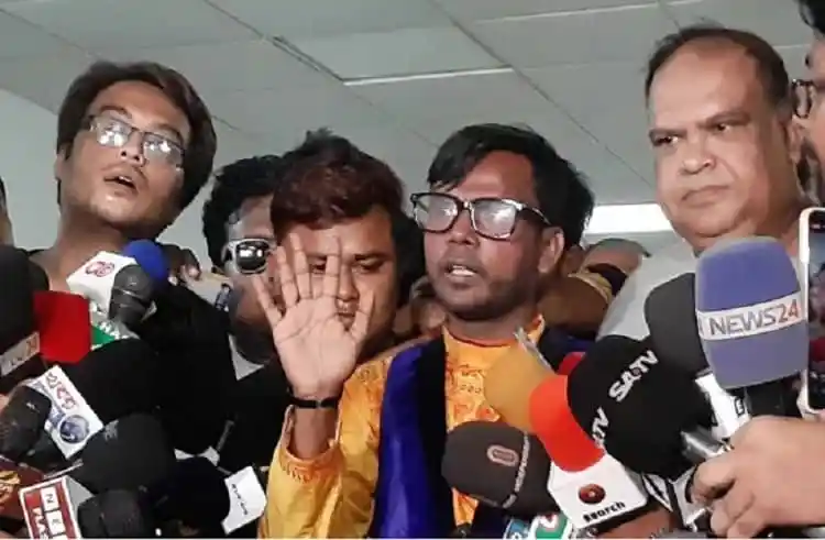 হিরো আলম সাংবাদিকদের সাথে কথা বলছেন, বেশ কয়েকটি মাইক্রোফোনের সামনে।. Channel i News - চ্যানেল আই নিউজ