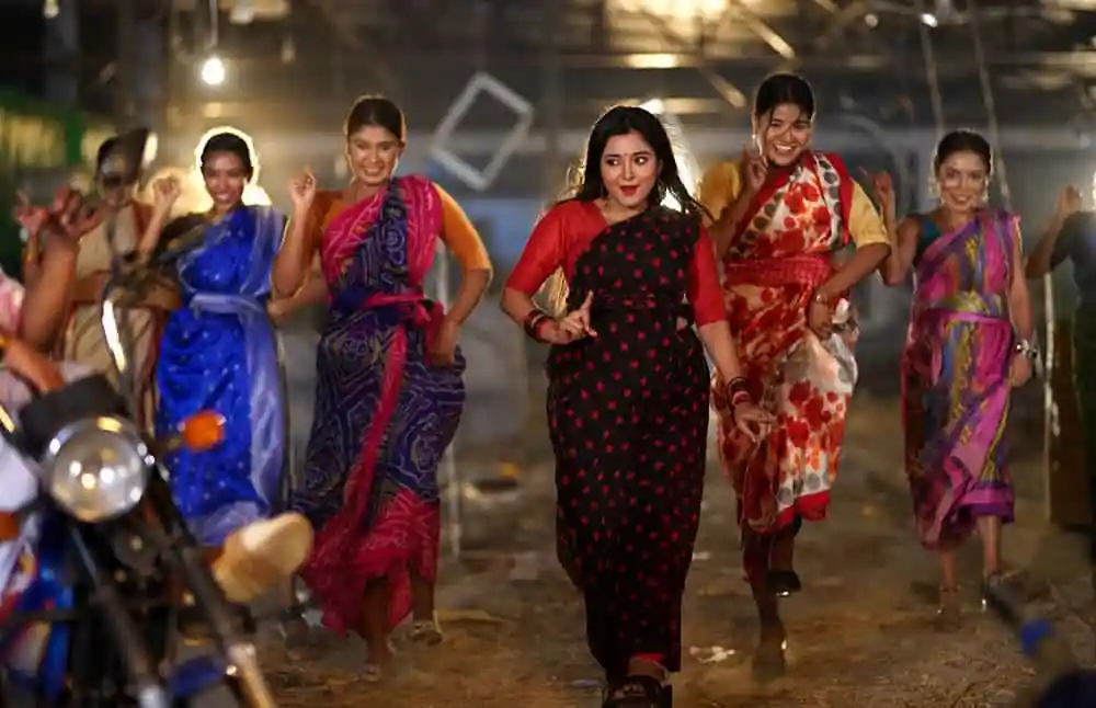 বিভিন্ন তসিবার পোশাক পরা নারীরা একসঙ্গে হাঁটছেন, উৎসবমুখর পরিবেশে. Channel i News - চ্যানেল আই নিউজ