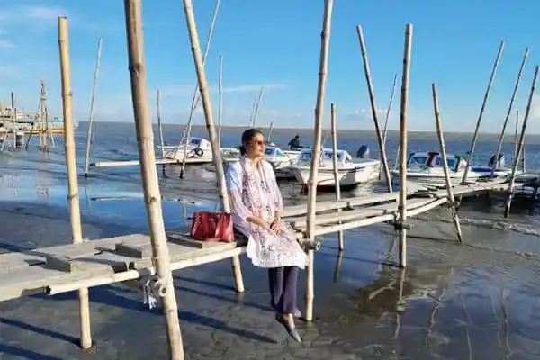 মৈনট ঘাটে বসে নদীর দৃশ্য উপভোগ করছেন একজন নারী. Channel i News - চ্যানেল আই নিউজ