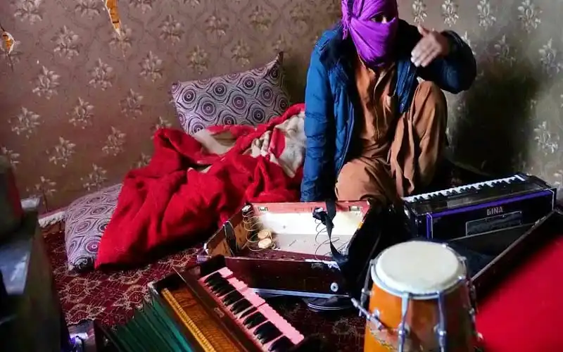 একজন ব্যক্তি পাগড়ি পরা ও বাদ্যযন্ত্র বাজাচ্ছেন. Channel i News - চ্যানেল আই নিউজ
