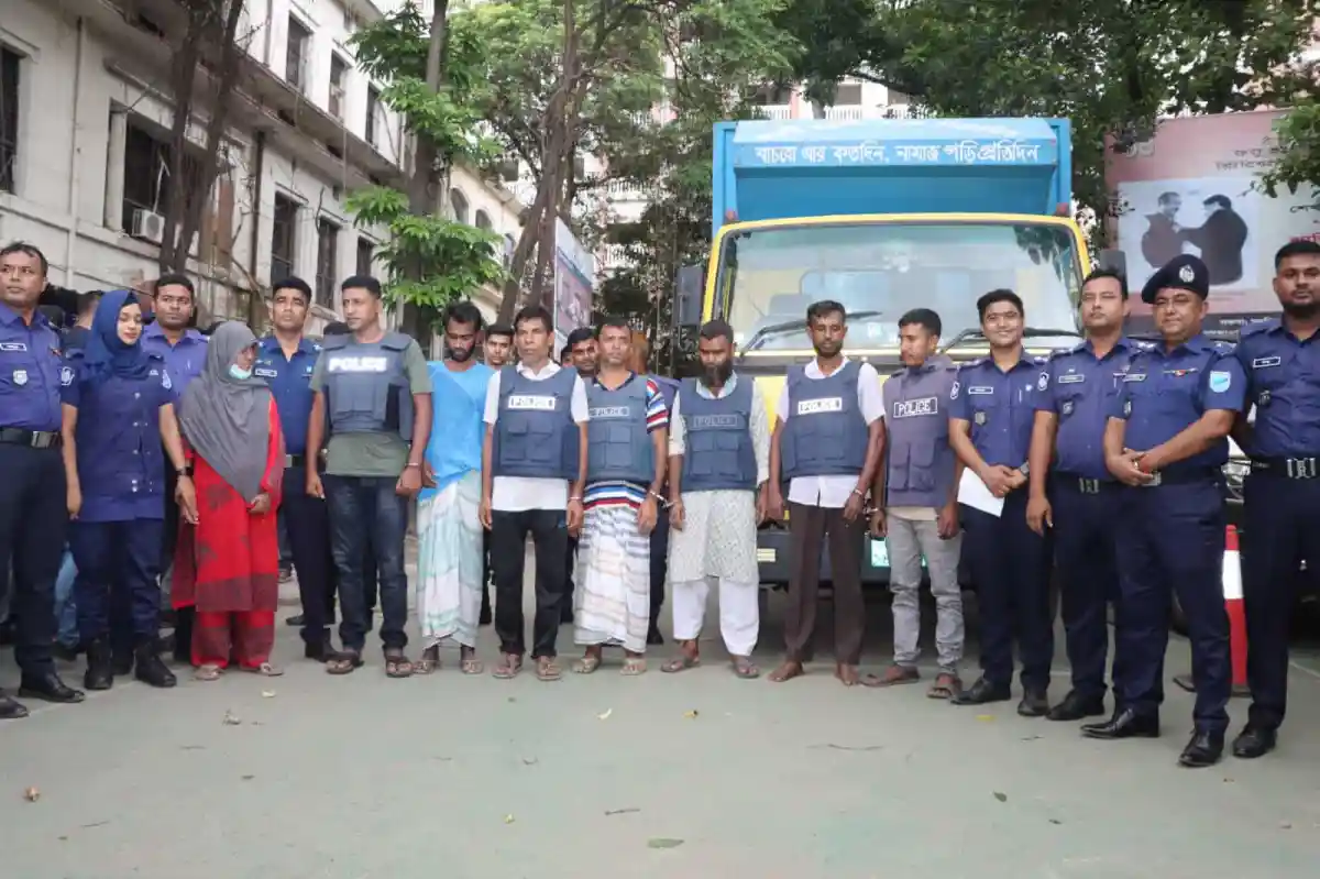 বাংলাদেশে পুলিশ ও আটক ব্যক্তিরা একটি সড়কে দাঁড়িয়ে আছেন. Channel i News - চ্যানেল আই নিউজ