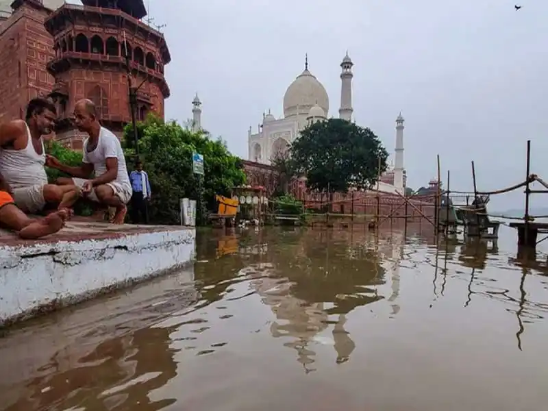 তাজমহলের পাশে বন্যার পানি, মানুষ বসে আলোচনা করছে. Channel i News - চ্যানেল আই নিউজ