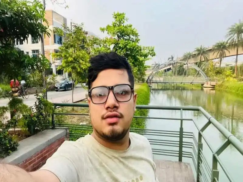 জাবি ক্যাম্পাসে একজন শিক্ষার্থী ছবি, প্রকৃতি ও ভবনের পেছনে নদী ও গাছের দৃশ্য. Channel i News - চ্যানেল আই নিউজ