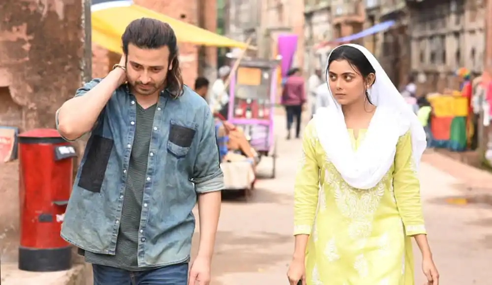 একজন যুবক ও যুবতী রাস্তার পাশে হাঁটছেন, ব্যস্ত বাজারের পটভূমিতে. Channel i News - চ্যানেল আই নিউজ
