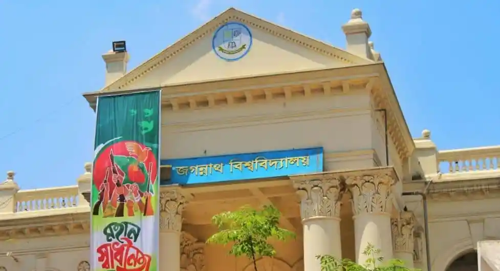 জগন্নাথ বিশ্ববিদ্যালয় ভবনের সামনে পতাকা ও সাইনবোর্ড দেখা যাচ্ছে. Channel i News - চ্যানেল আই নিউজ