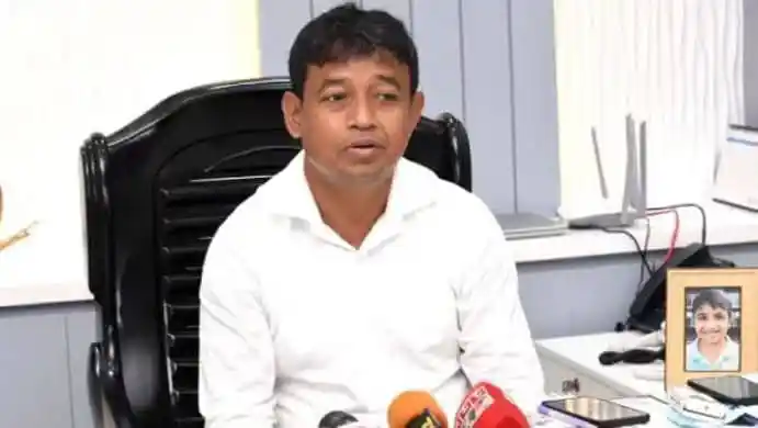 Bangladeshi man speaking at a press conference with microphones. Channel i News - চ্যানেল আই নিউজ