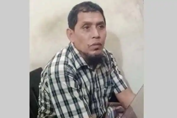 অভিযুক্ত ব্যক্তি বৃষ্টির মধ্যে বসে, চেহারা চিন্হিত করা কঠিন. Channel i News - চ্যানেল আই নিউজ