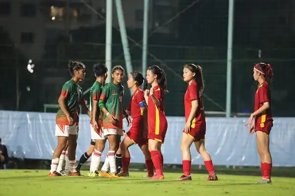 বাংলাদেশ নারী ফুটবল দলের খেলোয়াড়রা মাঠে একে অপরের সাথে আলোচনা করছে।. Channel i News - চ্যানেল আই নিউজ