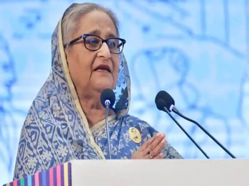 প্রধানমন্ত্রী শেখ হাসিনা ভাষণ দিচ্ছেন, পুতুলের সামনে দাঁড়িয়ে. Channel i News - চ্যানেল আই নিউজ
