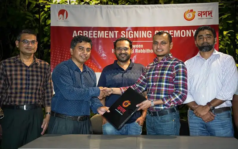 চুক্তি স্বাক্ষর অনুষ্ঠানে পাঁচজন ব্যক্তি হাসিমুখে হাত মিলাচ্ছেন।. Channel i News - চ্যানেল আই নিউজ