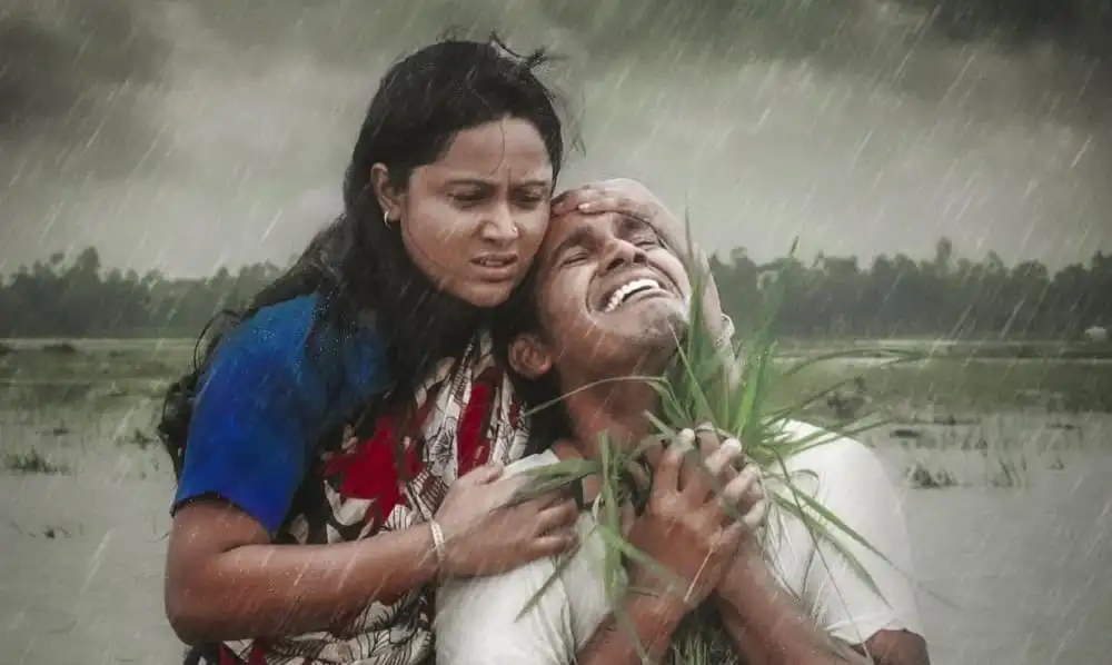 দুজন মানুষ বৃষ্টিতে ভিজে একে অপরকে সান্ত্বনা দিচ্ছেন. Channel i News - চ্যানেল আই নিউজ