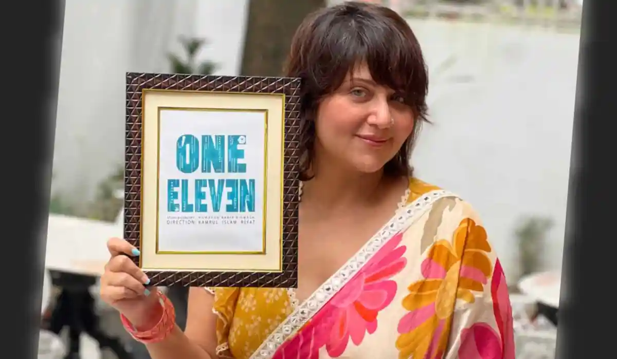 স্বস্তিকা holding a framed 'One Eleven' sign at an event. Channel i News - চ্যানেল আই নিউজ