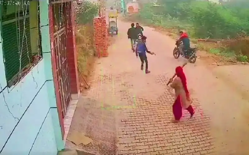 নারী হাতে ঝাড়ু দিয়ে চারজন বন্দুকধারীকে তাড়াচ্ছেন. Channel i News - চ্যানেল আই নিউজ