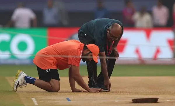 ক্রিকেট মাঠে একজন খেলোয়াড় মেঝেতে বসে আছেন, পাশে একজন কর্মকর্তা।. Channel i News - চ্যানেল আই নিউজ
