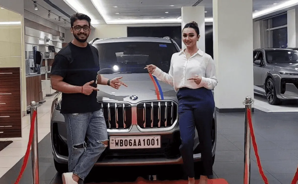 দুটি ব্যক্তি নতুন বিএমডাব্লিউ গাড়ির সামনে দাঁড়িয়ে হাসিমুখে ছবি তুলছেন. Channel i News - চ্যানেল আই নিউজ