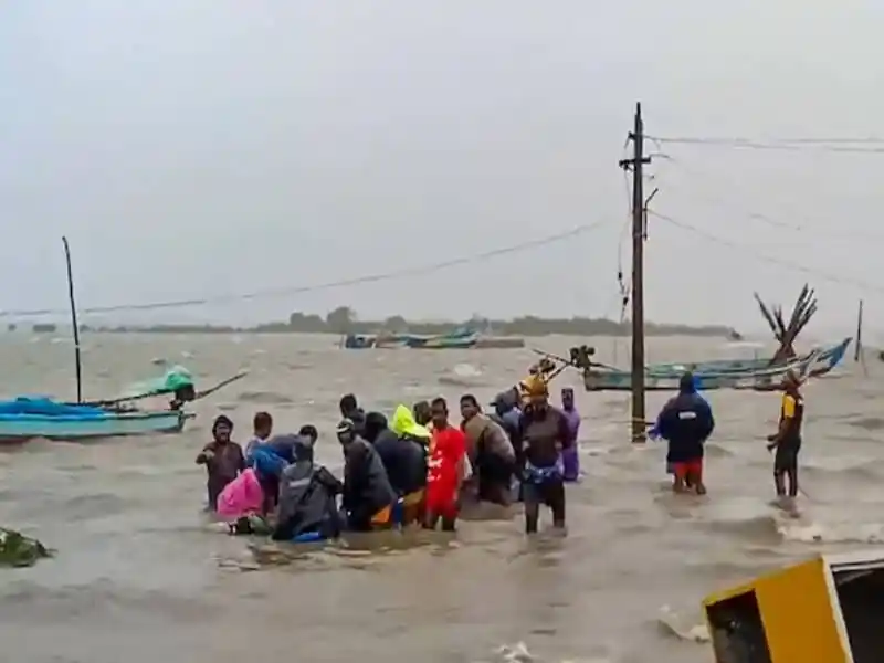 চেন্নাইয়ে ঘূর্ণিঝড়ের কারণে মানুষ পানিতে দাঁড়িয়ে উদ্ধার কাজ করছে. Channel i News - চ্যানেল আই নিউজ