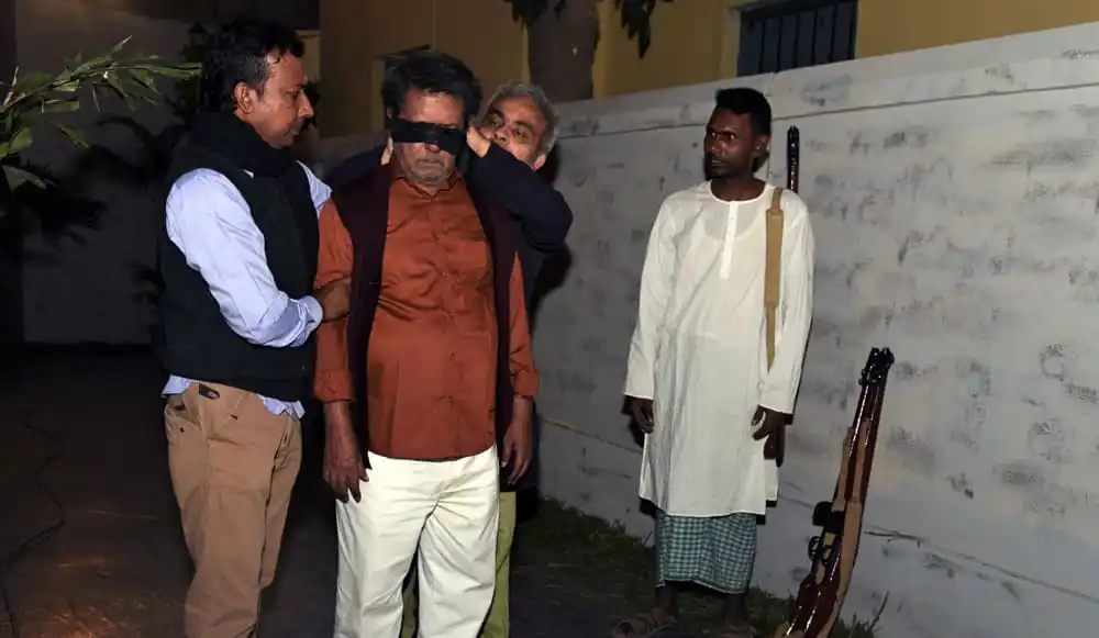 নাটকের দৃশ্যে চার ব্যক্তি, একজন চোখে ব্লাইন্ডফোল্ড, অন্যরা তাকে সাহায্য করছে. Channel i News - চ্যানেল আই নিউজ