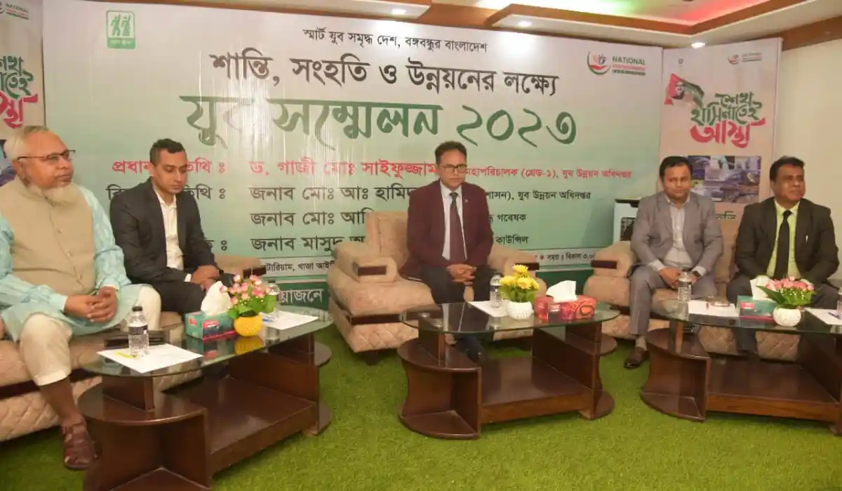আলোচনা সভায় অংশগ্রহণকারী ব্যক্তিরা বসে আছেন, পেছনে ব্যানার দেখা যাচ্ছে. Channel i News - চ্যানেল আই নিউজ