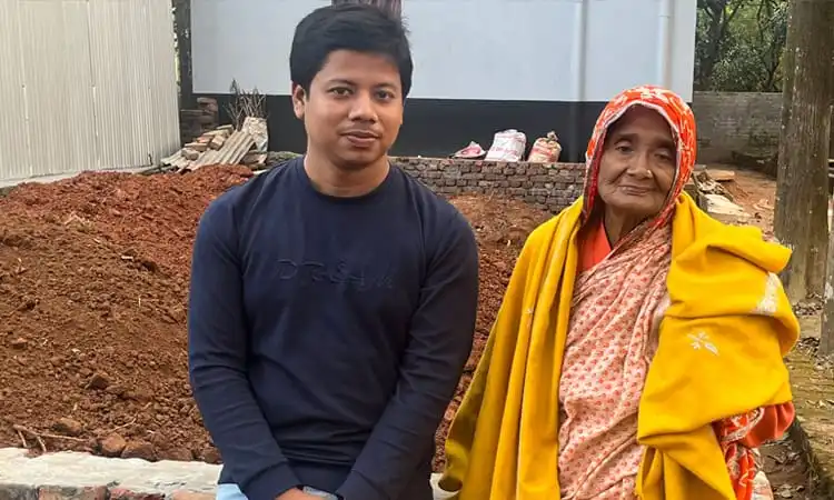 বৃদ্ধা ও যুবক একসঙ্গে বসে আছেন, প্রকৃতি পেছনে. Channel i News - চ্যানেল আই নিউজ