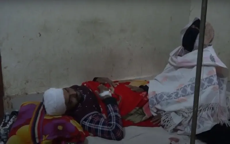 আহত ব্যক্তি হাসপাতালে শয্যাশায়ী, মাথায় সেলাই ও ব্যান্ডেজ. Channel i News - চ্যানেল আই নিউজ