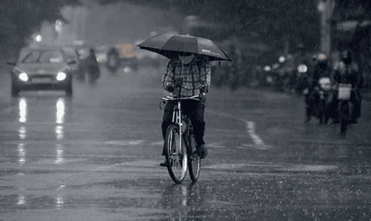 বৃষ্টির মধ্যে সাইকেল চালাচ্ছেন একজন ব্যক্তি, ঢাকায় রাস্তায় জল জমে গেছে. Channel i News - চ্যানেল আই নিউজ