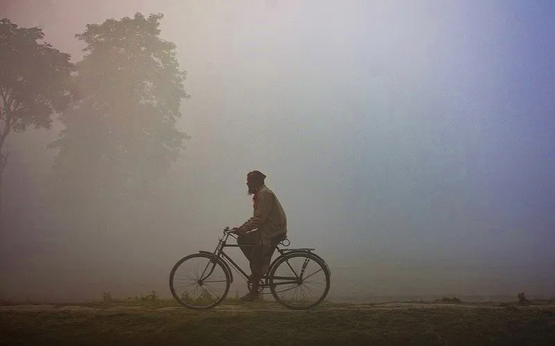 ধোঁয়ায় ঢাকা শহর, শীতের সকালে বাইসাইকেল চালাচ্ছে একজন ব্যক্তি. Channel i News - চ্যানেল আই নিউজ