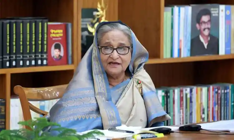 প্রধানমন্ত্রী শেখ হাসিনা সাক্ষাৎকার দিচ্ছেন, বইয়ের সামনে বসে. Channel i News - চ্যানেল আই নিউজ