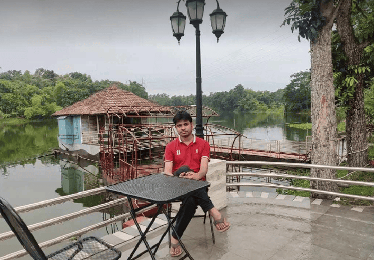 নদীর পাশে বসে যুবক, প্রকৃতি ও জলাশয় দৃশ্য. Channel i News - চ্যানেল আই নিউজ