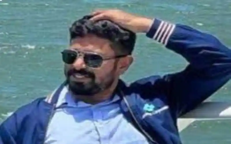 একজন ব্যক্তি সাগরে দাঁড়িয়ে হাসছেন, sunglasses পরা. Channel i News - চ্যানেল আই নিউজ