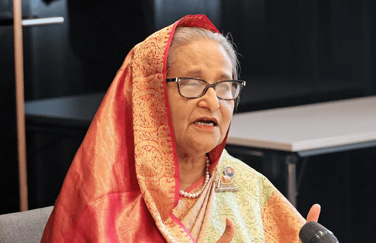 প্রধানমন্ত্রী শেখ হাসিনা ভাষণ দিচ্ছেন, পেছনে কনফারেন্স রুম।. Channel i News - চ্যানেল আই নিউজ