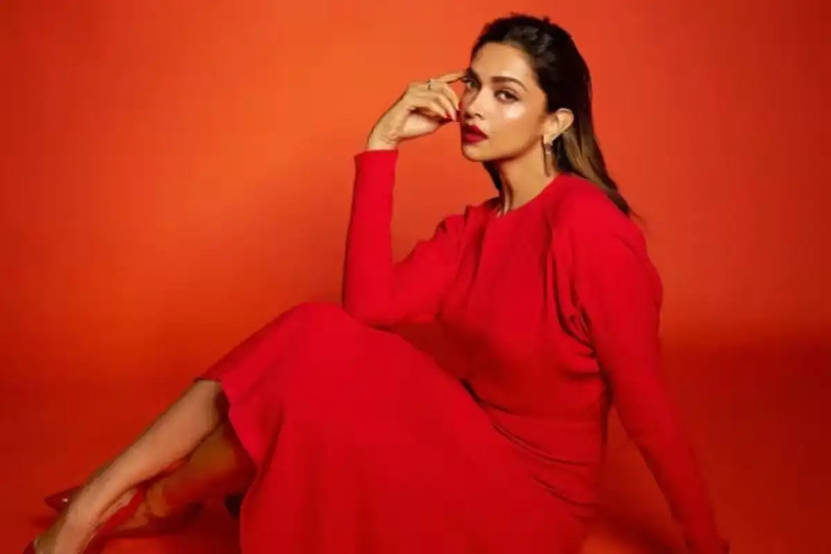 দীপিকা বাফটার মঞ্চে দাঁড়িয়ে পোজ দিচ্ছেন, লাল পোশাক পরা. Channel i News - চ্যানেল আই নিউজ