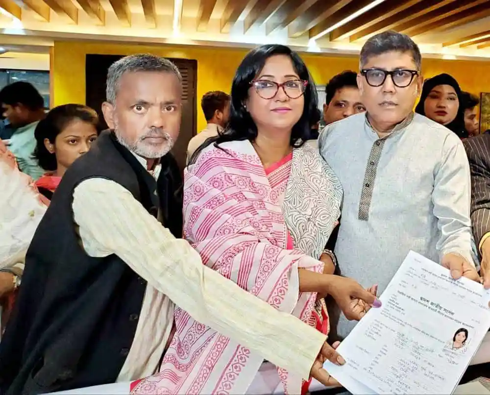 সংবাদ সম্মেলনে অংশগ্রহণকারী তিনজন ব্যক্তি, একটি পত্রিকা দেখাচ্ছেন. Channel i News - চ্যানেল আই নিউজ