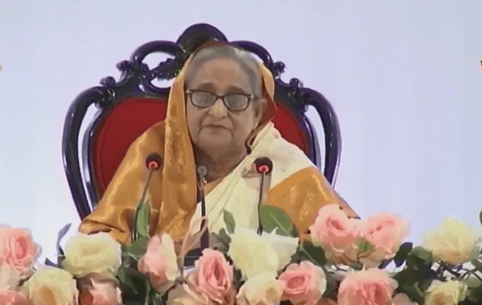 প্রধানমন্ত্রী ভাষণে বসে আছেন, ফুলের টেবিলের সামনে. Channel i News - চ্যানেল আই নিউজ