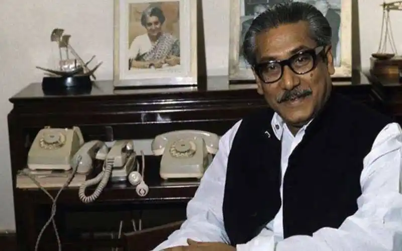 বঙ্গবন্ধুর ছবি সহ একজন ব্যক্তি স্মারক অনুষ্ঠানে অংশগ্রহণ করছেন. Channel i News - চ্যানেল আই নিউজ