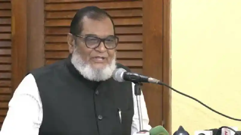 বাংলাদেশের একজন নেতা ভাষণ দিচ্ছেন, পেছনে কাঠের দরজা. Channel i News - চ্যানেল আই নিউজ